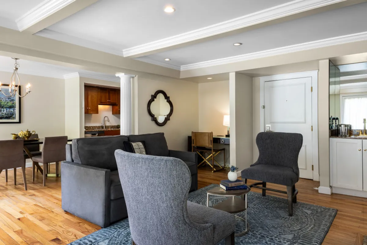 A stylish interior scene showcasing a comfortable seating area adjacent to a dining space, all accented by modern decor. The open layout suggests a seamless connection between living and dining zones, encouraging social interaction and relaxed gatherings.